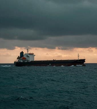 Bulk carrier under way in open sea at dusk
