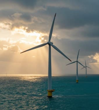 Offshore wind turbines with sunlight breaking through cloud